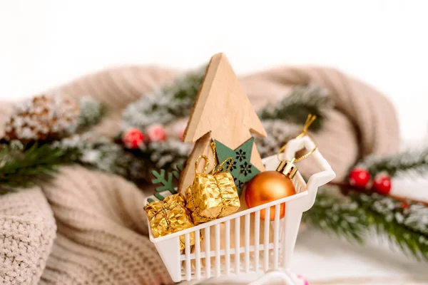 Caixas de presente de Natal em um carrinho de compras com flocos de neve decorativos ao redor, conceito de venda de Natal. camisola de malha acolhedora. — Fotografia de Stock