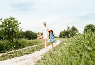 a walk along a country road, mom and daughter, a path in the field, years of a village. forest or outdoors park.