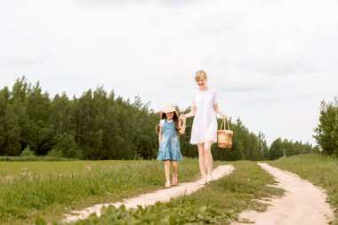 a walk along a country road, mom and daughter, a path in the field, years of a village. forest or outdoors park.