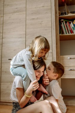 Evde yerde üç çocuk oynuyorlar. Mutlu kahkahalar Mutlu aile kavramı. Tutkulu aşk.