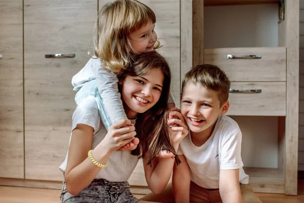 Niños felices jugando casas en el suelo. Ríete y diviértete, familia feliz. Concepto de hermana feliz y hermano.Película granulada — Foto de Stock