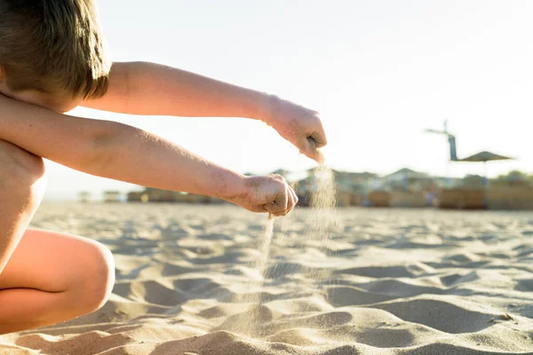 Άμμος κάστρο φτιαγμένο από άμμο από τα χέρια ενός παιδιού στην ακτή. Θάλασσα στο ηλιοβασίλεμα, λευκή άμμος στην παραλία. — Φωτογραφία Αρχείου