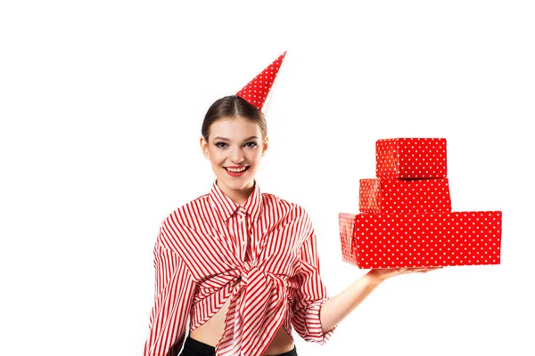 Una mujer joven sostiene la caja de regalo. Sonriente chica feliz sobre fondo blanco. Una gran cantidad de cajas rojas. Chica en una fiesta, cumpleaños o día de San Valentín. — Foto de Stock