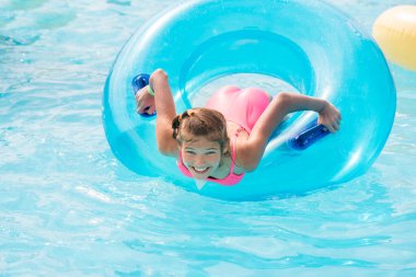 Komik kız su sıçratan bir suyla hızlı bir su yolculuğuna çıkıyor. Su parkı konseptiyle yaz tatili.