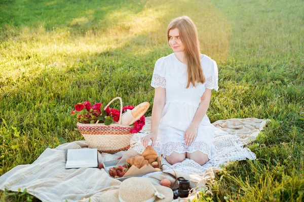 雏菊中的田野，一束花。法国风格的浪漫野餐背景。女人穿着棉衣,戴着帽子,草莓,羊角面包,毛毯上的花,俯瞰全景.户外采集概念 — 图库照片