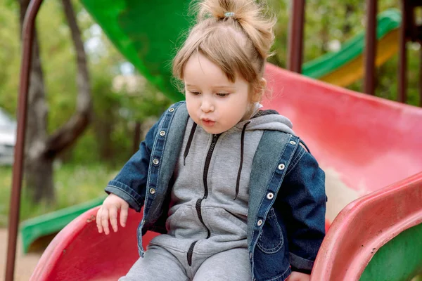 Щаслива маленька дівчинка-малюк на дитячому майданчику.Дитячі ігри в парку на відкритому повітрі. Дитяча радість і щастя. — стокове фото