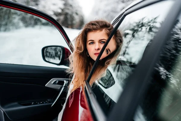 Car travel. A girl in a red car, winter travel.