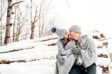 Kütüğün üzerinde oturan tatlı bir çift, kış ormanı. Sanat eserleri.