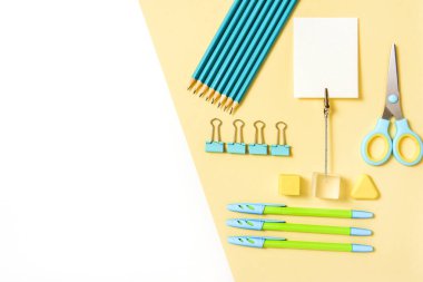 okul araçları mavi ve sarı arka plan üst görünüm knoling. Okula dönüş, okul gereçleri - kalemler ve boyalar, cetvel ve silgi, ataç ve makas, not defterleri ve defterler