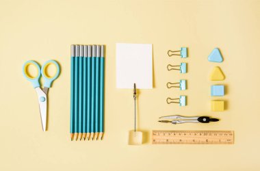 okul araçları mavi ve sarı arka plan üst görünüm knoling. Okula dönüş, okul gereçleri - kalemler ve boyalar, cetvel ve silgi, ataç ve makas, not defterleri ve defterler