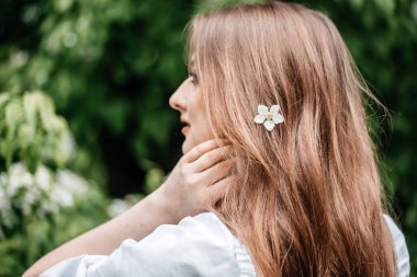 Çiçek açan kiraz çiçeklerinin bahçesinde güzel genç bir kadın. tomurcuk saç, yaşam tarzı