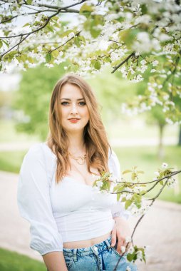 Bahar kiraz bahçesinde güzel sarışın kız
