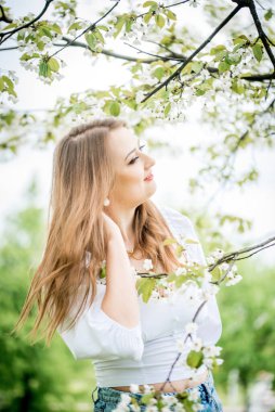 Bahar kiraz bahçesinde güzel sarışın kız