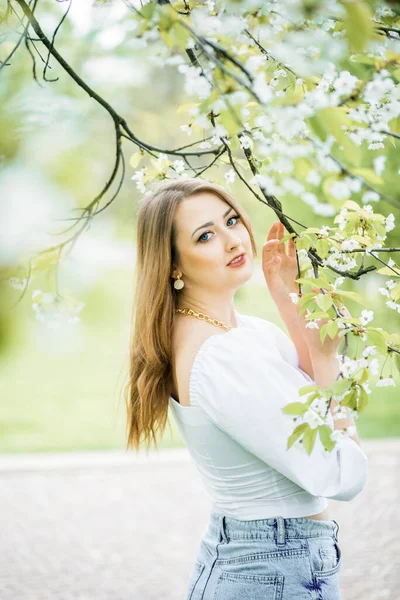 Beautiful blonde girl in spring cherry garden — Stock Photo, Image