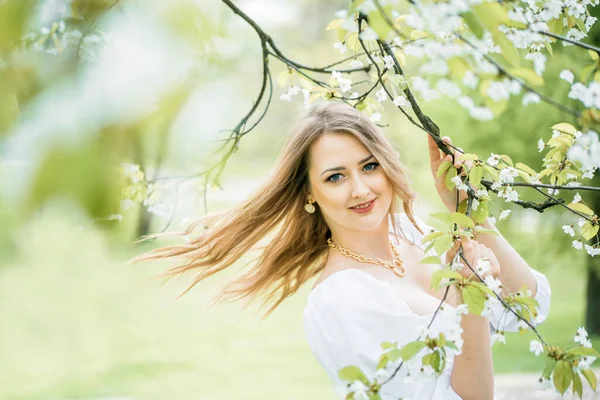 Красивая блондинка в весеннем вишневом саду — стоковое фото