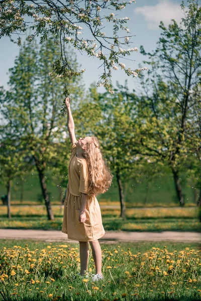 Счастливая эмоциональная сладкая девочка танцует и играет с мыльными пузырями, наслаждаясь солнечным днем в парке. — стоковое фото