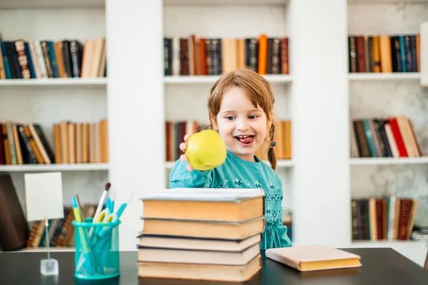 Щаслива дитина, здорова їжа, дівчинка їсть фрукти в школі — стокове фото