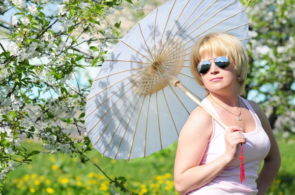 Girl with an umbrella in the lush garden Royalty Free Stock Images