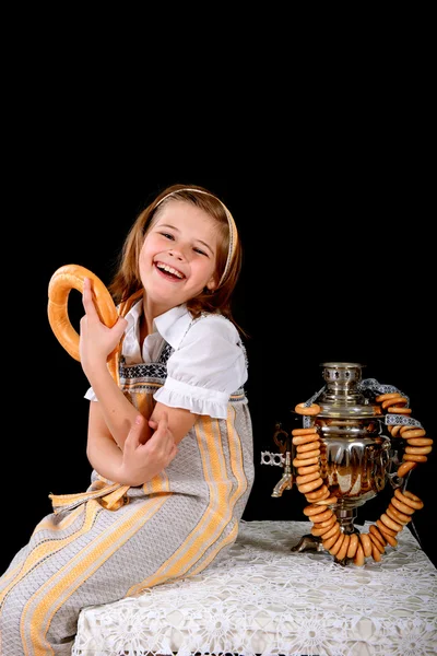 Menina russa comendo bagels e bebe chá de um samovar — Fotografia de Stock