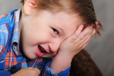 Gülen çocuk portresi gözleri elini kapatır