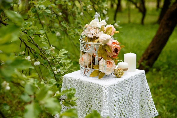 Rosa blommor, ljus på stickad duk. Inredningen på bordet i parken. — Stockfoto