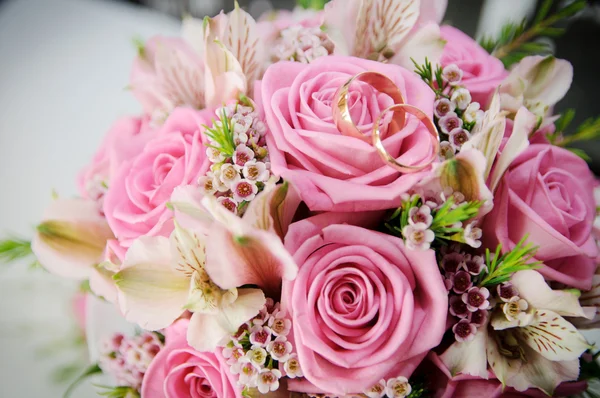 Bouquet nuptial de roses. Anneaux de mariage couchés sur une fleur — Photo