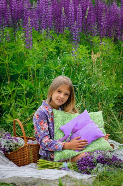 Beautiful laughing girl in a field of purple lupine flowers. — Stock Photo, Image