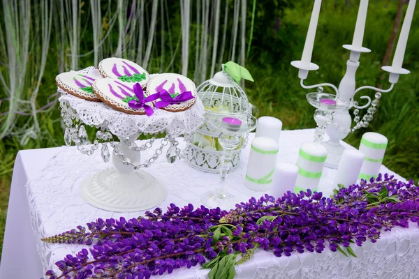 Decoração de casamento. Flores de tremoço azuis, velas e cartas, bela decoração. Bolo de gengibre — Fotografia de Stock