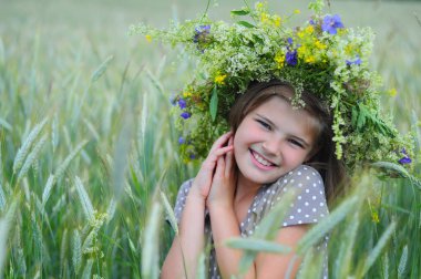 Kulakları alanında kapalı gözlü mutlu gülümseyen kız. Kafasına çiçek çelenk