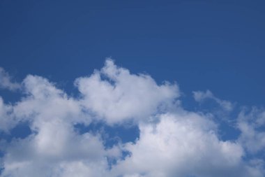 Beyaz bulutlu mavi bir zemin üzerinde bulutlar.