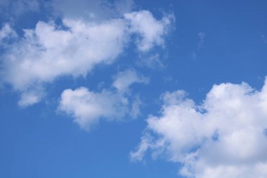 Beyaz bulutlu mavi bir zemin üzerinde bulutlar.