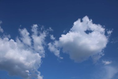 Beyaz bulutlu mavi bir zemin üzerinde bulutlar.