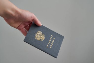 Rusya Federasyonu 'nun çalışma kitabı. Gri arka planda beyaz bir kızın elinde. Boşluğu kopyala