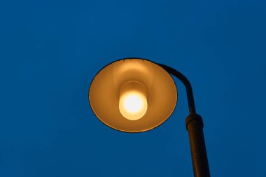 Arka planda alacakaranlık gökyüzü olan bir sokak lambası. Boşluğu kopyala.