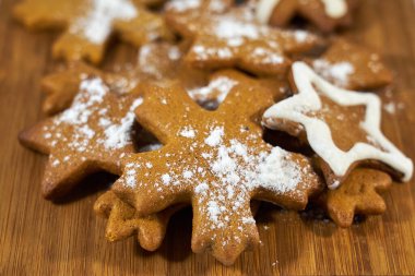 Zencefilli bisküviler ahşap bir tahtanın üzerinde şeker tozuyla kaplıdır..
