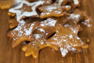Zencefilli bisküviler ahşap bir tahtanın üzerinde şeker tozuyla kaplıdır..