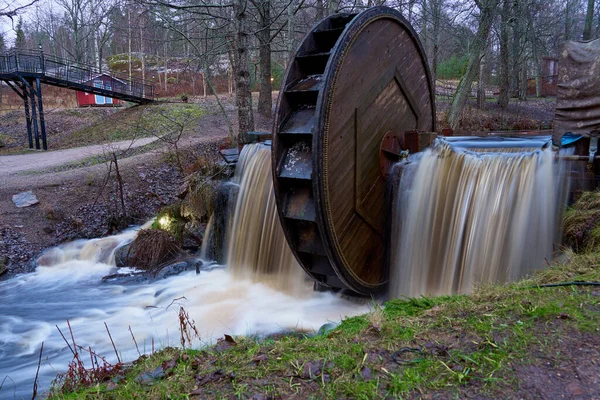 An old wooden water wheel on a waterfall. Copy space.