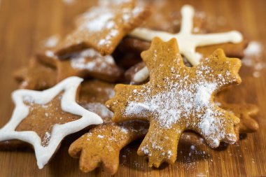Zencefilli bisküviler ahşap bir tahtanın üzerinde şeker tozuyla kaplıdır..