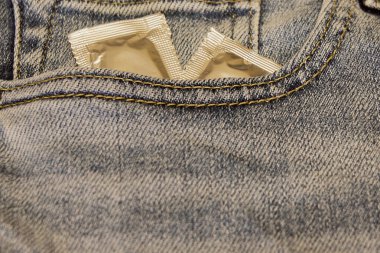 Kot pantolonun cebinde gümüş ambalajlı kondomlar.