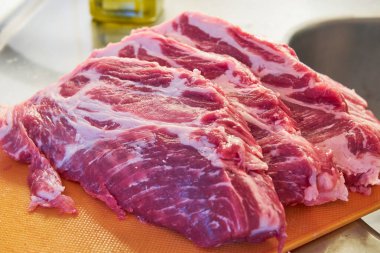 The pork steaks on a cutting board.