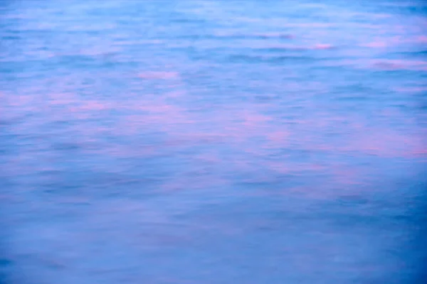 Ondas borrosas del mar al atardecer como fondo. — Foto de Stock