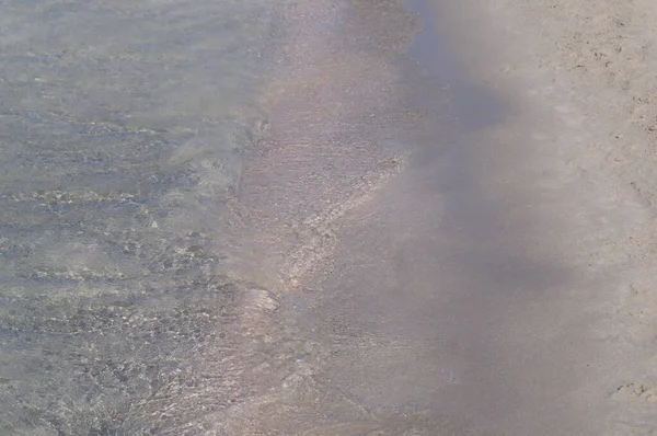 Kristallinkirkas vesi Elafonisin hiekkarannalla Kreikassa. — kuvapankkivalokuva