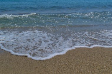 Kumsal, güzel deniz dalgaları. Beyaz deniz köpüğü.