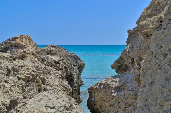 Kilátás az azúrkék tengerre és a kék égre a köveken keresztül. — Stock Fotó