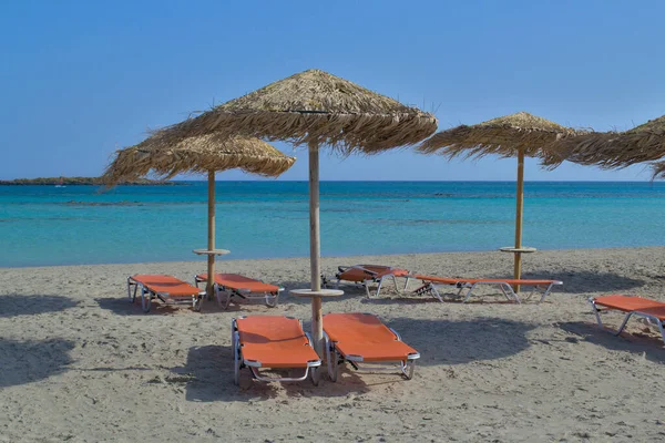 Sonnenliege und Sonnenschirm an einem schönen Sandstrand. — Stockfoto