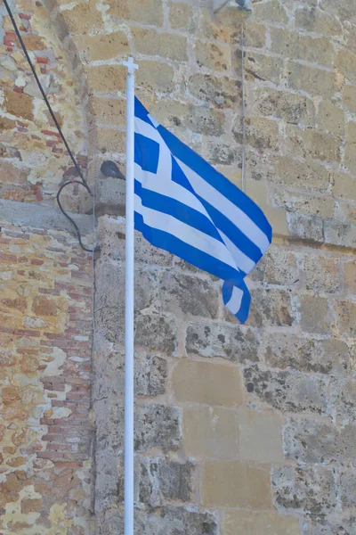 Eski bir taş duvarın arkasında Yunan bayrağı. — Stok fotoğraf