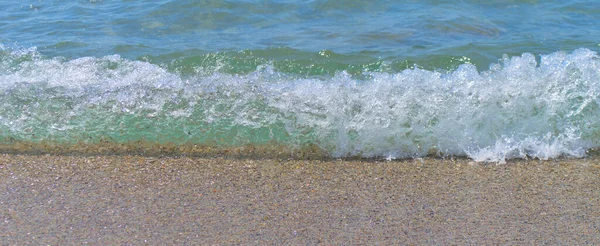 Onda blu del mare con schiuma primo piano sulla riva sabbiosa. — Foto Stock