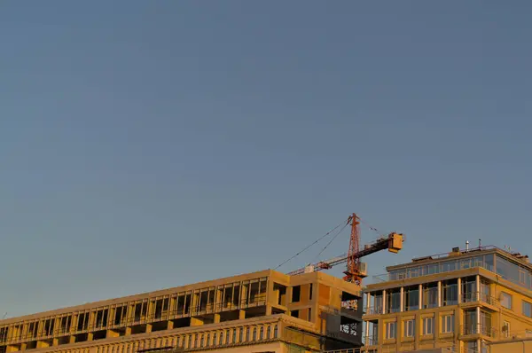 Construção de um edifício de vários andares no fundo de um céu azul. — Fotografia de Stock