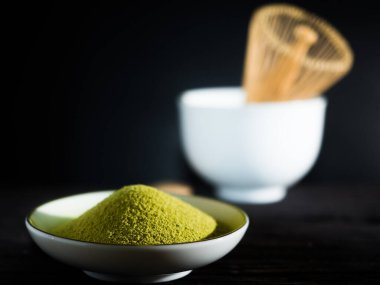 Yeşil çayı kapat, kibrit gücünü arttır ve bir fincan sıcak yeşil çayı ahşap masada çırp. Geleneksel Japon içeceği.