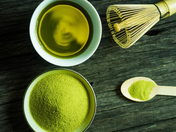 close up green tea, matcha power and whisk a cup of hot green tea on wooden table.traditional japanese drink